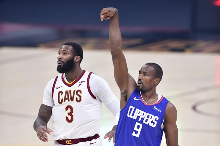 Feb 3, 2021; Cleveland, Ohio, USA; LA Clippers center Serge Ibaka (9) reacts to his three-point basket beside Cleveland Cavaliers center Andre Drummond (3) in the first quarter at Rocket Mortgage FieldHouse. Mandatory Credit: David Richard-USA TODAY Sports